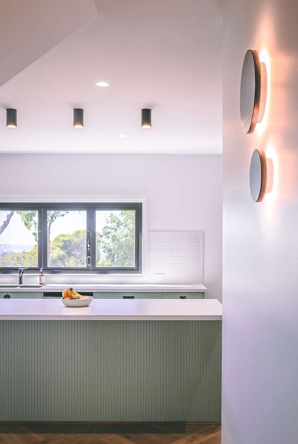 Kitchen Island in mint and white colour and lighting fixtures details